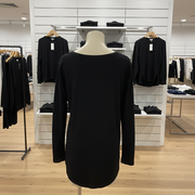Black long-sleeve top on a mannequin in a store setting with clothing racks in the background.