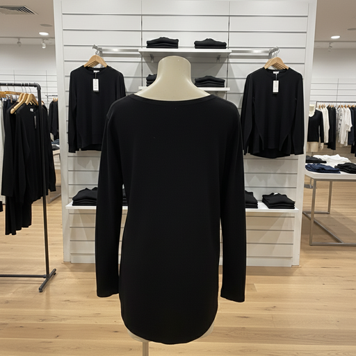 Black long-sleeve top on a mannequin in a store setting with clothing racks in the background.