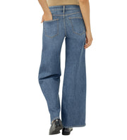 Blue jeans worn by a person on a white background