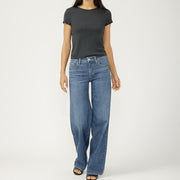 Person wearing a black t-shirt and blue jeans on a white background